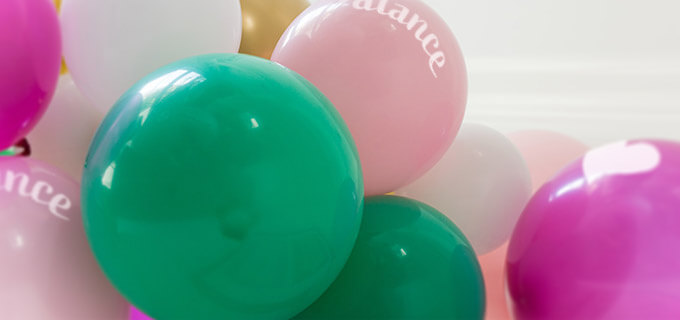 Viele bunte Luftballons sind mit einem Firmenlogo bedruckt