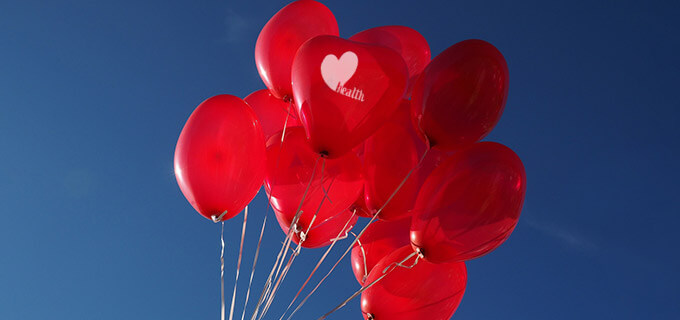 Mehrere rote Herzluftballons schweben in der Luft